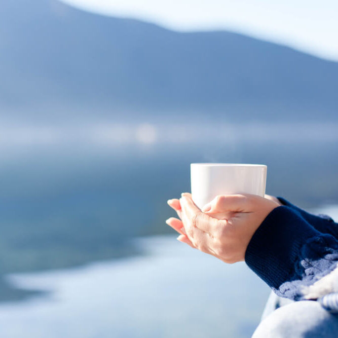 Woman drinks coffee at sea beach