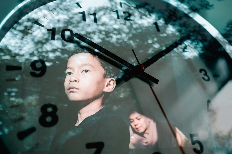 Reflection of mother and son in wall clock