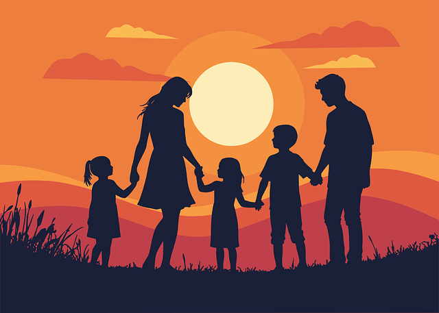 Silhouette of a family holding hands at sunset.
